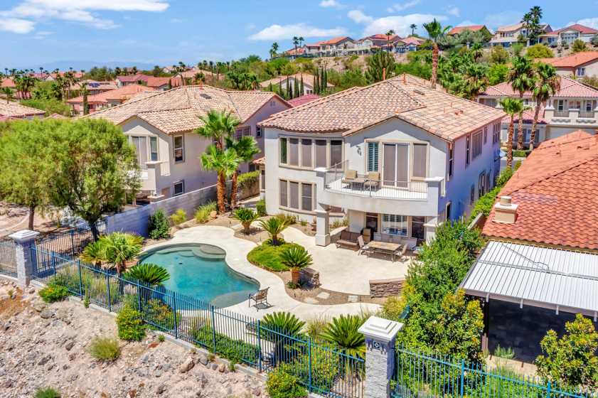 backyard pool with balcony drone photo of backyard with pool and view of mountain